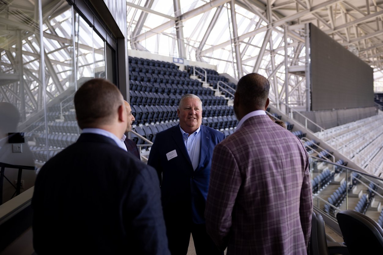 Attendees tour the seating bowl at TQL Stadium during the Marathon Health event.
