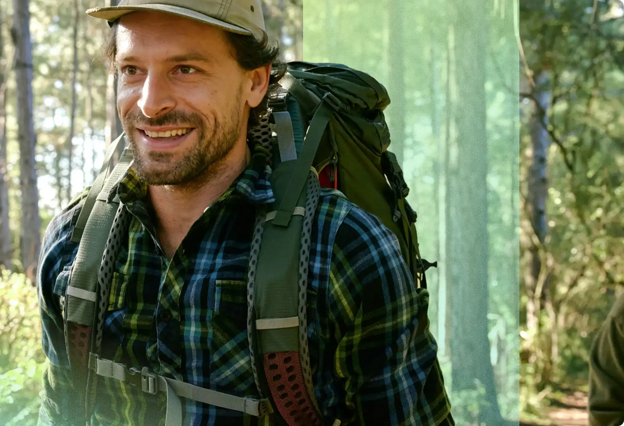 Smiling hiker walking through the woods in Colorado.