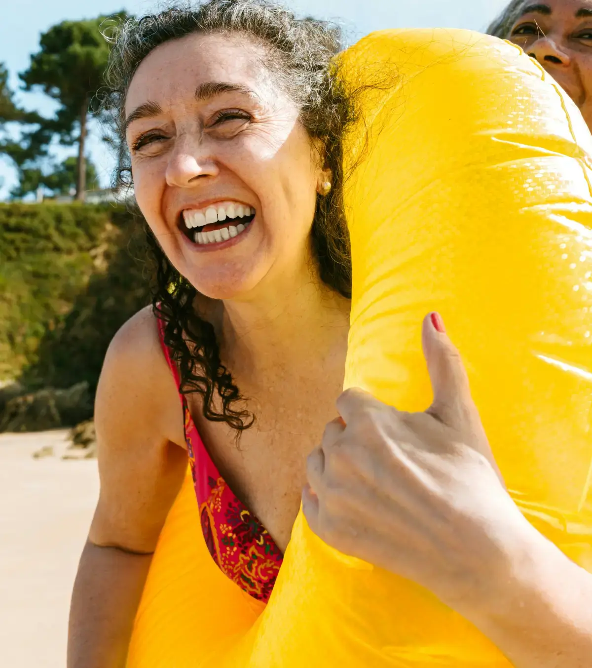 Smiling woman holding a pool toy.