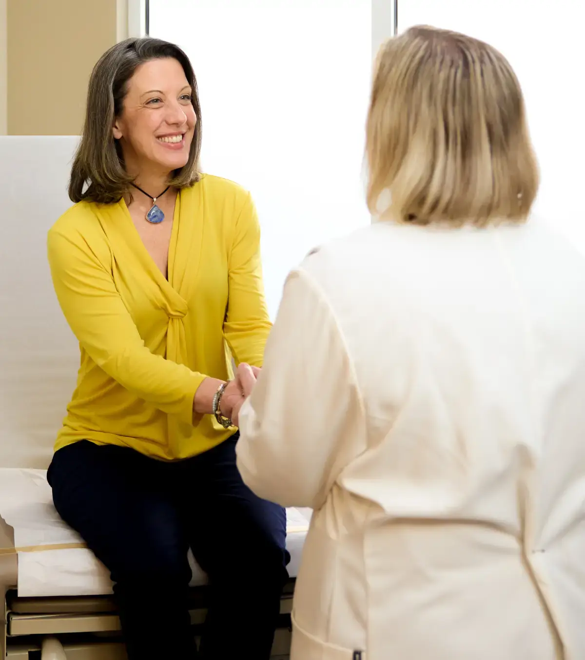 Smiling woman speaking with a female doctor.