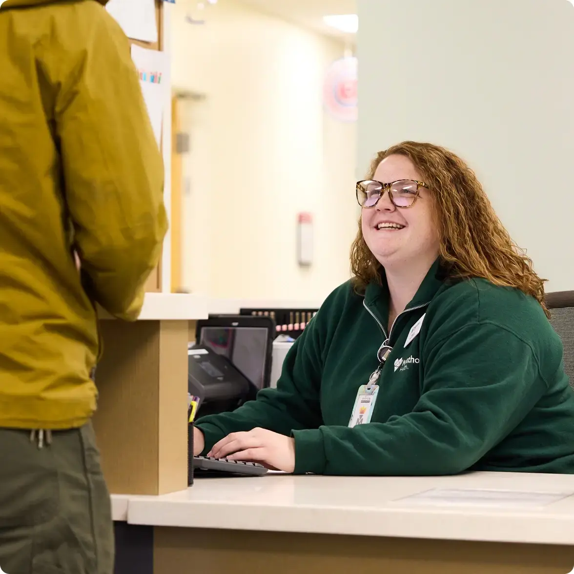 Receptionist at a Marathon Health center speaking with an arriving patient.