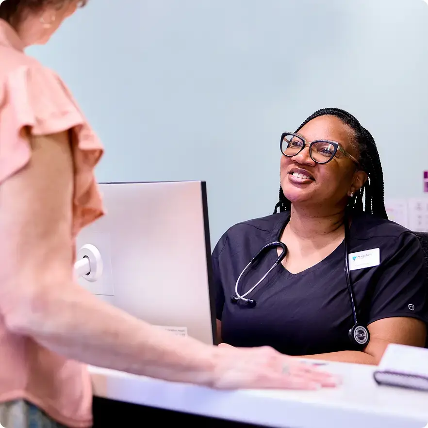 Marathon Health network health center receptionist greeting a patient.