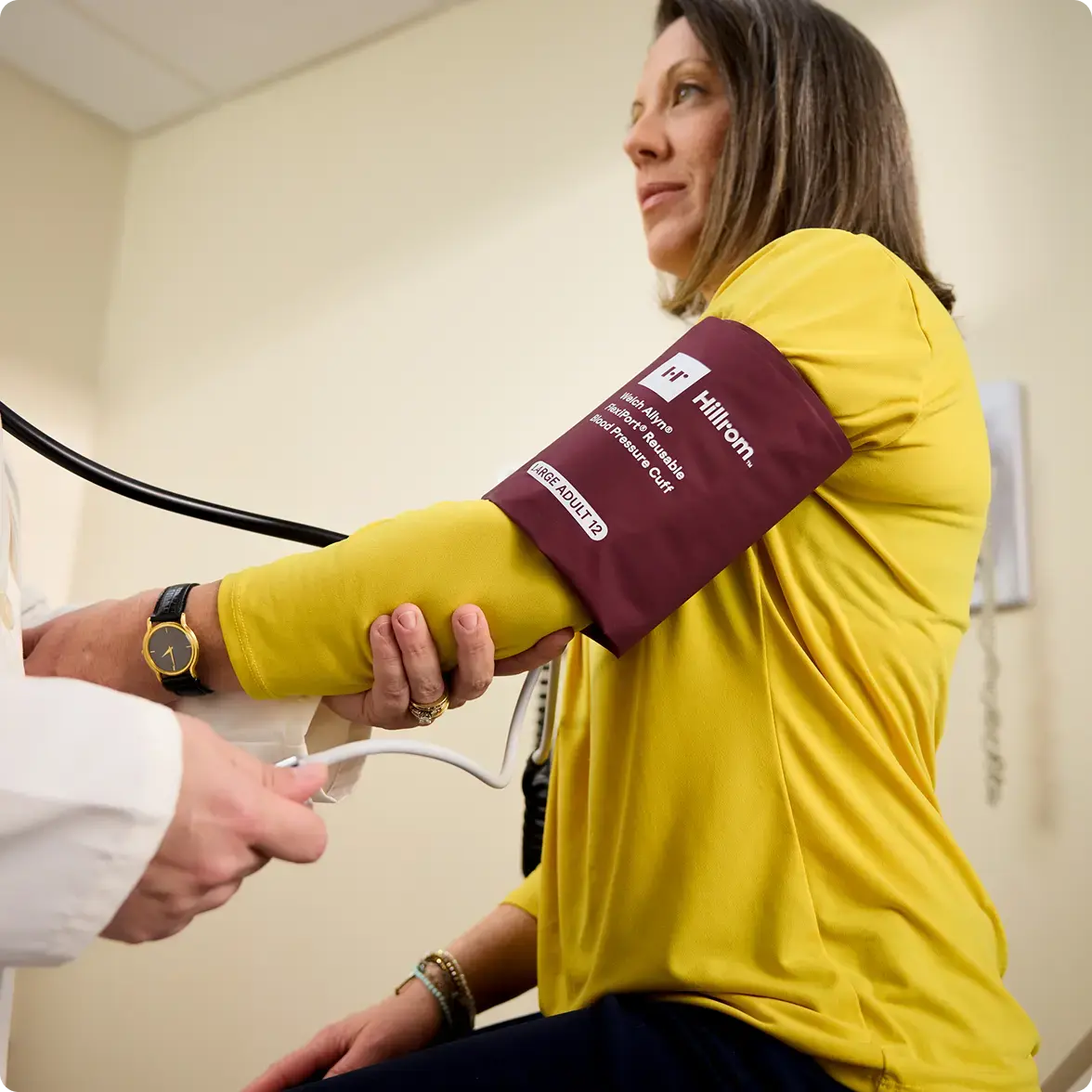 Patient getting their blood pressure measured by a healthcare practitioner in a clinical setting.