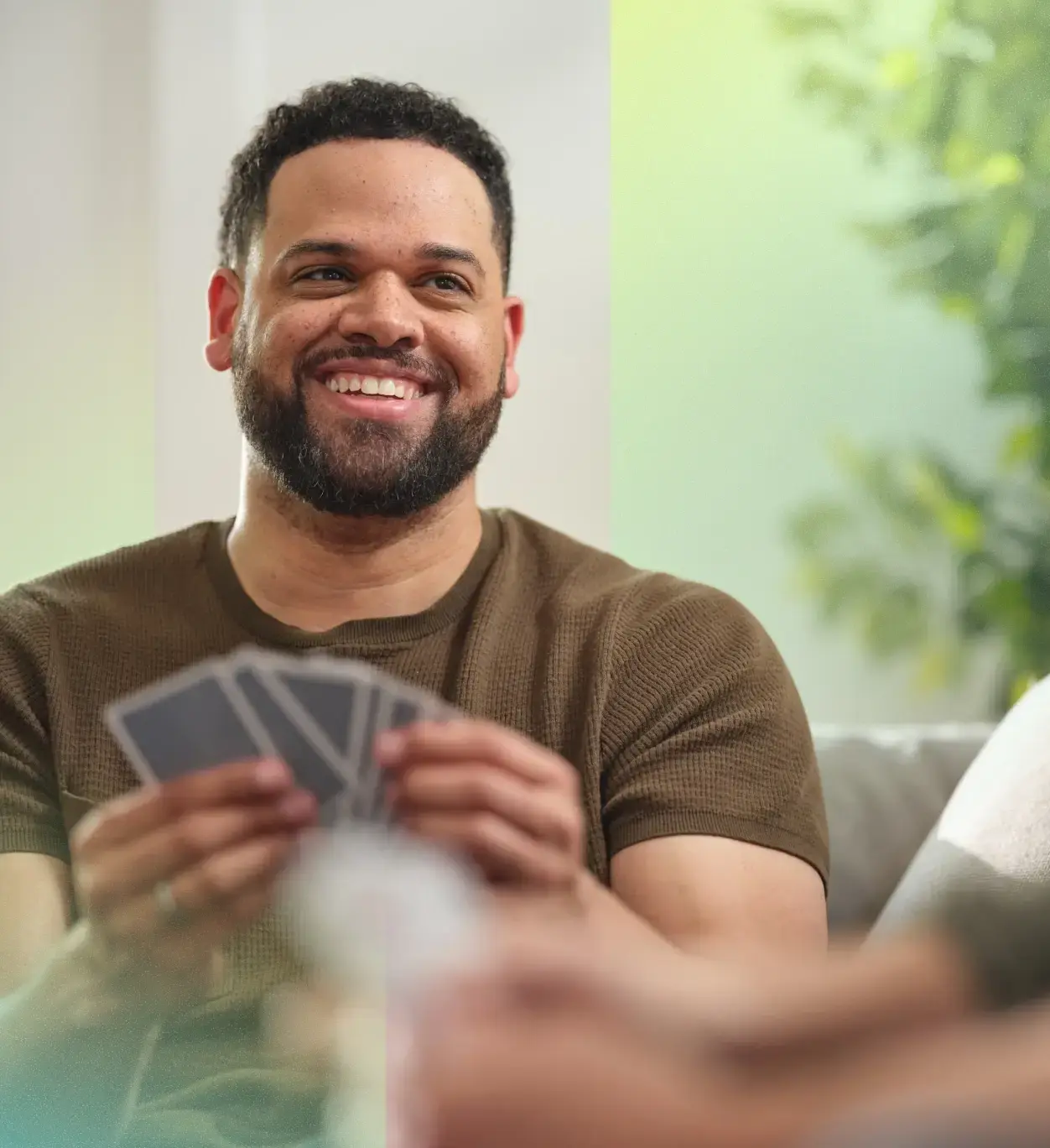 Smiling person playing a game of cards.