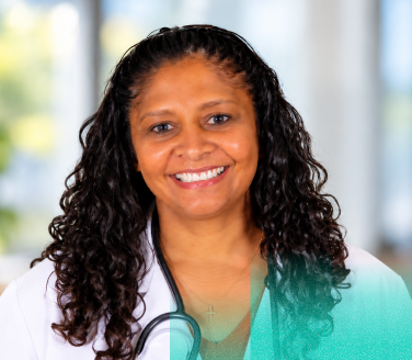 Dr. Aasha Trowbridge, medical director of virtual care at Marathon Health, smiling in a white lab coat with a stethoscope.