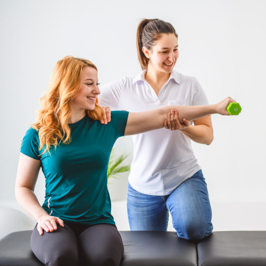 Physical therapist guiding a patient through an arm exercise using a hand weight.