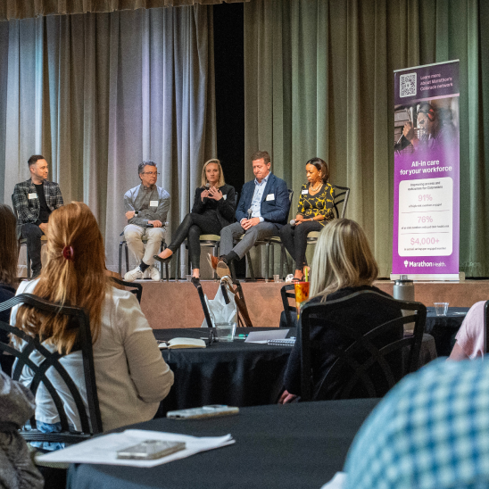 Panel discussion at the Colorado mental health access roundtable with audience seated at tables.