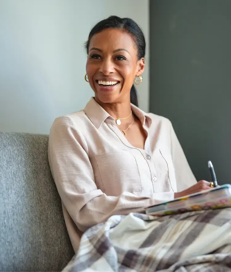 Happy, healthy woman sitting while having a conversation with a trusted care provider.