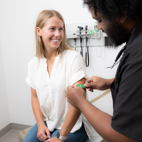 Healthcare provider administering care to an employee at an onsite health center appointment.