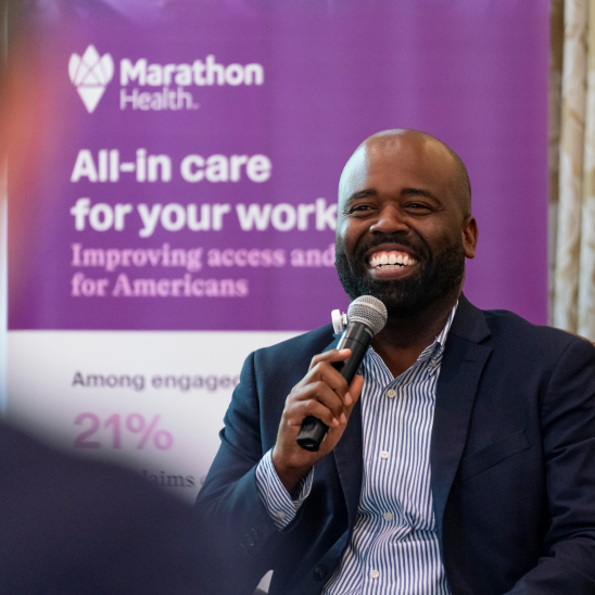 Dr. Raynard Washington laughing while speaking at the Marathon Health Charlotte roundtable.