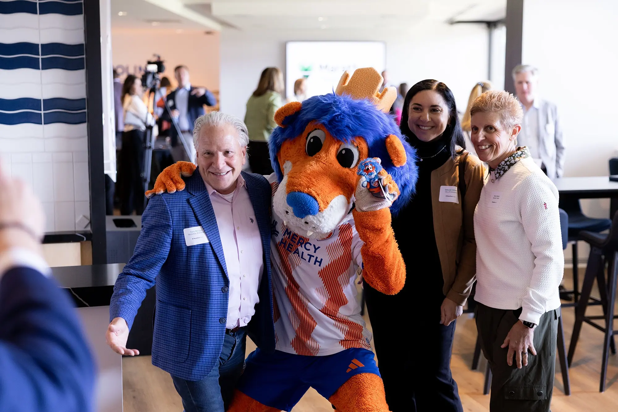 Attendees pose with the Mercy Health mascot at the TQL Stadium event.