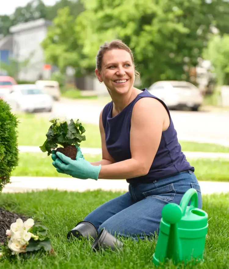 Smiling woman gardening in her front yard.